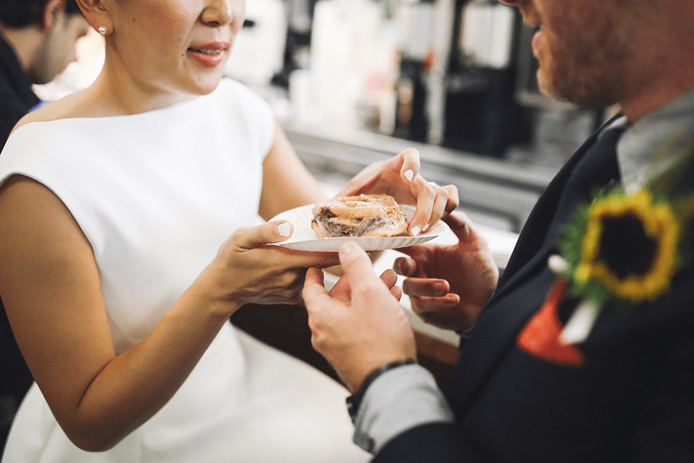 bride and groom eating donuts